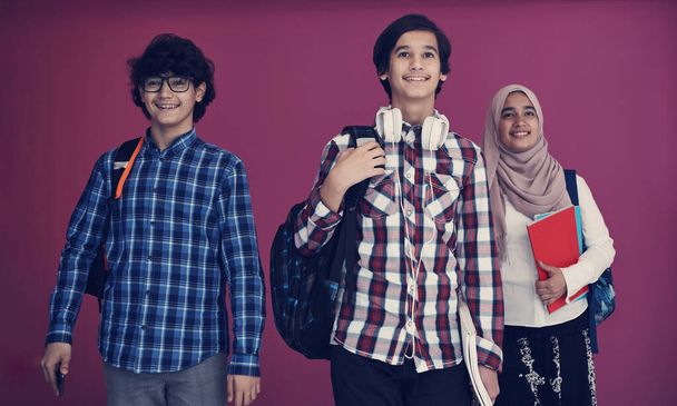 Arabic teenagers group, students team walking forward in future and back to school concept pink background - Foto, afbeelding