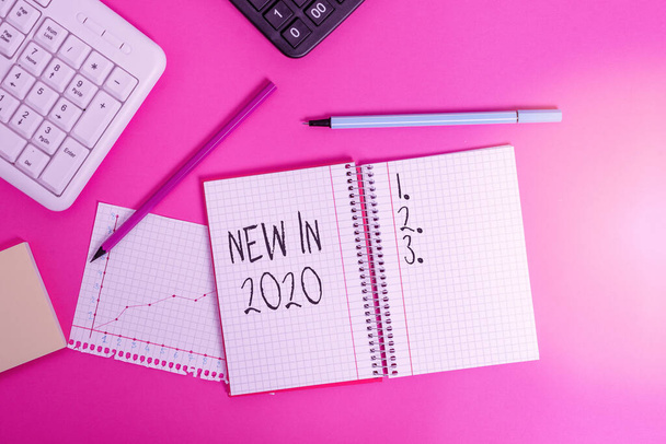 Teksti näyttää New In 2020. Käsitteellinen kuva siitä, mitä odotetaan tai uusi luomus vuodelle 2020 Kirjoittaminen laitteiden ja tietokoneiden yläpuolella klassinen puinen pöytä
. - Valokuva, kuva