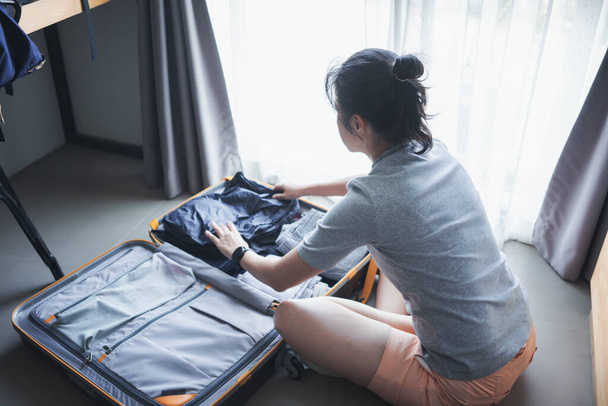 Mulher embalando roupas para embalar uma bagagem para uma nova viagem, férias de verão, viagens, conceito
 - Foto, Imagem