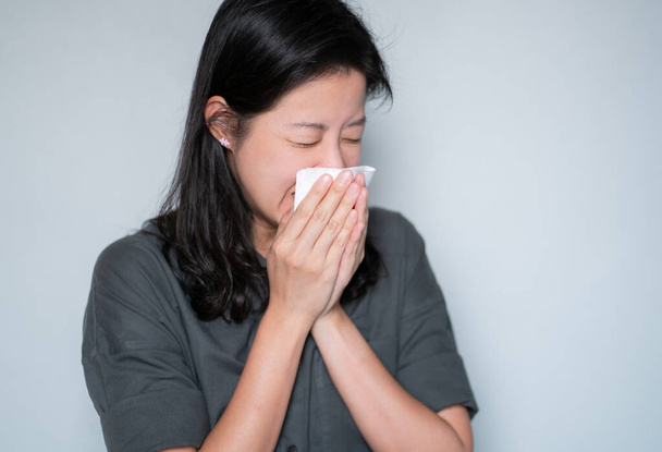 Virüs, baş ağrısı. Asyalı kadın hasta ve odada kağıt mendille hapşırıyor.. - Fotoğraf, Görsel