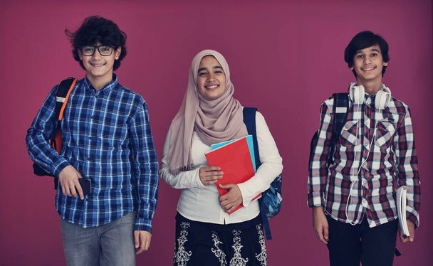 Arabic teenagers group, students team walking forward in future and back to school concept pink background - Φωτογραφία, εικόνα