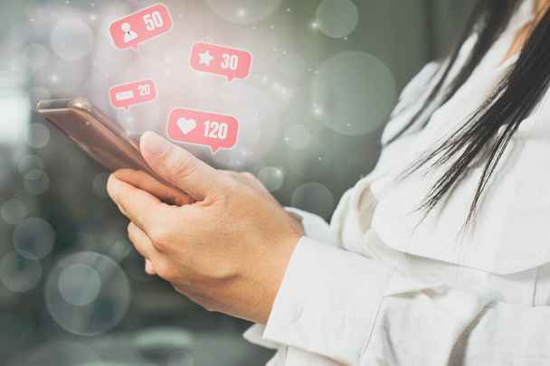 Mladá žena používat ruce držící smartphony sdílet Denní příběh na přítele a veřejnost s chytrým telefonem, růžová barva ikony na pozadí, koncept pomocí bezdrátových sítí aktualizovat informace sociálních médií. - Fotografie, Obrázek