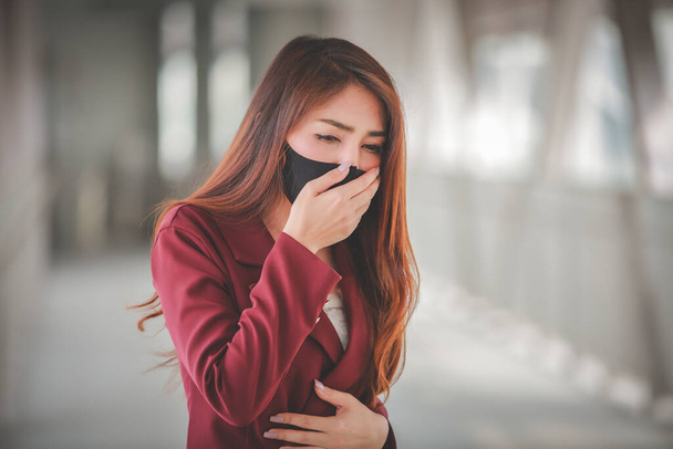 Mulher asiática usando máscara para proteger pm2.5 e tosse com surto de vírus Covid-19 em público.Mas ela com tosse intensa e dor no peito
. - Foto, Imagem