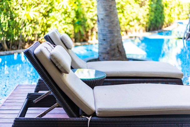 Lege stoel dek lounge rond zwembad in hotel resort voor reizen vakantie - Foto, afbeelding