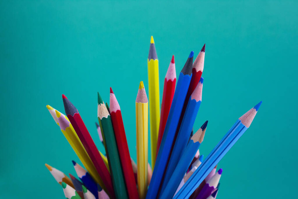 Pencils for drawing on a green background. Colored pencils. Office supplies. - 写真・画像