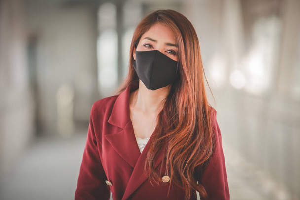 Mulher asiática usando máscara para proteger pm2.5 e tosse com surto de vírus Covid-19 em público
 - Foto, Imagem
