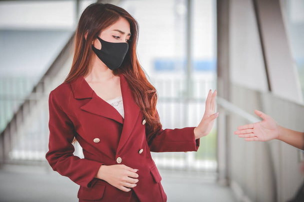 Due donne asiatiche evitano saluti senza tenersi per mano prevenire l'infezione, focolaio di Covid-19
. - Foto, immagini