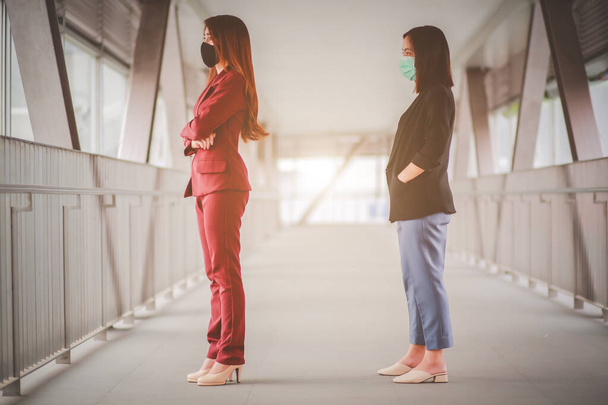 Δύο γυναίκες Ασιάτες στέκεται απόσταση 1 μέτρου από άλλους ανθρώπους να κρατήσει απόσταση προστασία από τους ιούς COVID-19 και οι άνθρωποι κοινωνική απόσταση για τον κίνδυνο μόλυνσης. - Φωτογραφία, εικόνα