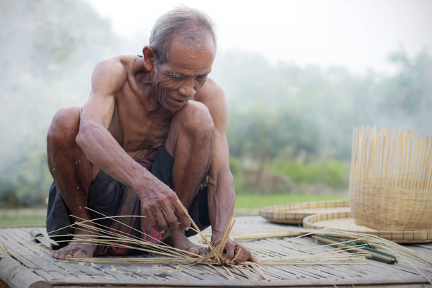 Yaşlı adam Tayland kırsalında bambu sepeti taşıyor.. - Fotoğraf, Görsel
