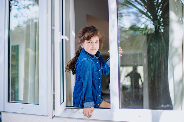 πορτρέτο της νεαρής κοπέλας που κοιτάζει έξω από το παράθυρο - Φωτογραφία, εικόνα
