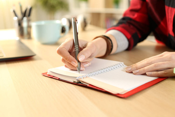 Detailní záběr studentky ruce psaní připomínka na pořadu jednání na stole v obývacím pokoji  - Fotografie, Obrázek