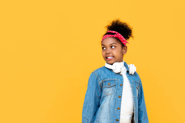 Hymyilevä muodikas mixed rodun Afrikkalainen tyttö katselee kopioi tilaa syrjään studio ammuttu eristetty värikäs keltainen tausta
 - Valokuva, kuva