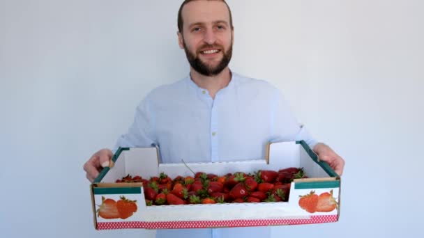 νεαρός όμορφος άντρας με ένα κουτί φράουλες. - Πλάνα, βίντεο