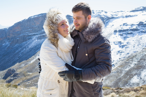 Loving couple in jackets against snowed mountain range - Photo, Image