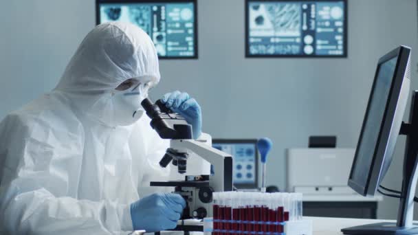 Вчений у захисному костюмі та масках, що працюють у науково-дослідній лабораторії, використовує лабораторне обладнання: мікроскопи, пробірки. Коронавірус 2019-московська небезпека, фармацевтичні відкриття, бактеріологія та вірусологія
 - Кадри, відео