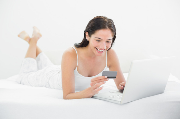 Casual woman doing online shopping in bed - Fotoğraf, Görsel