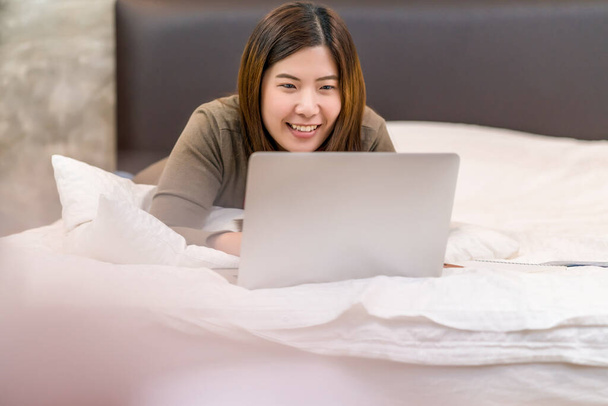 Asian business woman using technology laptop and working from home in indoor bedroom,freelance and entrepreneur,startups and business owner,lifestyle occupation,social distance and self responsibilit - Foto, Imagem
