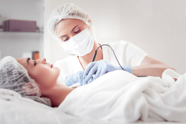 Beauty expert cleansing face using new ultrasound equipment - Valokuva, kuva