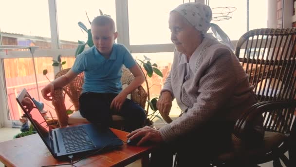 grandchildren teach 80 year old grandmother to work on a smartphone. playing with a smartphone. Make purchases online. are photographed. on the veranda of the house. Communicate on the Internet - Кадры, видео