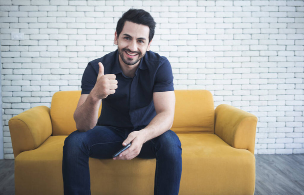 Portrait of handsome man showing thumbs up and smiling at camera. - Foto, Bild