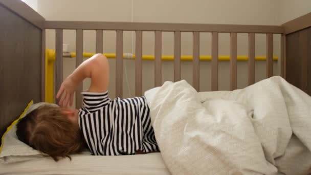 Anonymous toddler lying in crib - Footage, Video