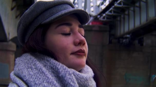 Close up of woman face looking up and enjoying outside leisure walking. Stock footage. A girl stands on the bank of the river near the bridge and thinks about something. - Footage, Video