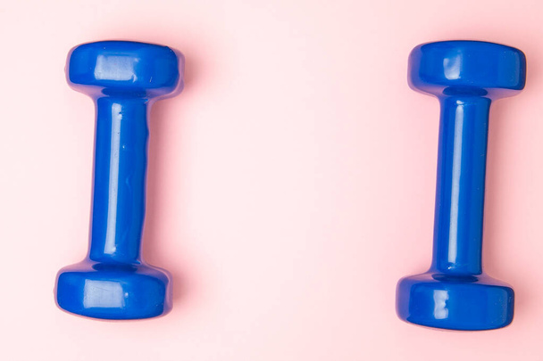 Two blue of dumbbells Isolated on pink background. - Photo, Image