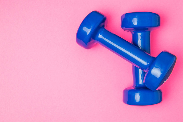 Two blue of dumbbells Isolated on pink background. - Photo, Image