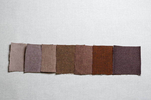 quadratische Stücke aus mehrfarbigem Stoff auf grauem Hintergrund - Foto, Bild