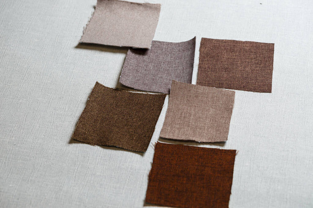 piezas cuadradas de tela multicolor dispuestas sobre un fondo gris
 - Foto, imagen