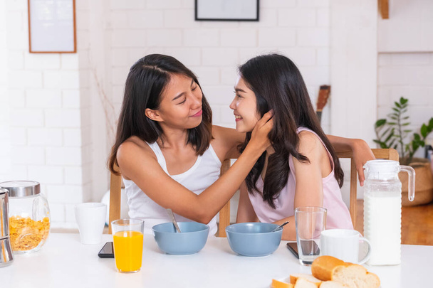 Szczęśliwy Azji lesbijka para śniadanie w domu rano z miłości i tender.LGBTQ styl życia koncepcja - Zdjęcie, obraz
