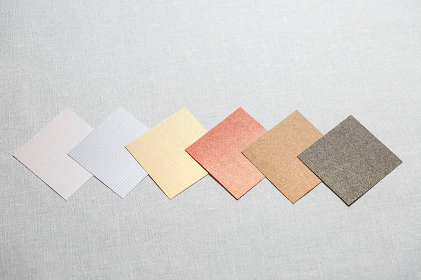 τετράγωνα κομμάτια πολύχρωμου υφάσματος τοποθετημένα σε γκρι φόντο - Φωτογραφία, εικόνα