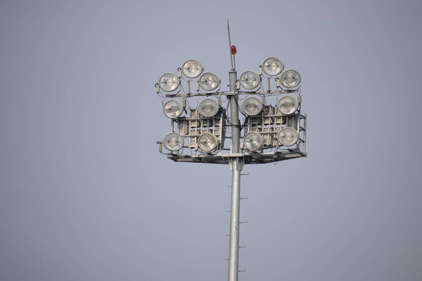 Крикет стадион прожекторы днем с голубым небом, высокая мощность прожекторов, трибуна и открытый крикет смол вечером в Дели Индия
 - Фото, изображение