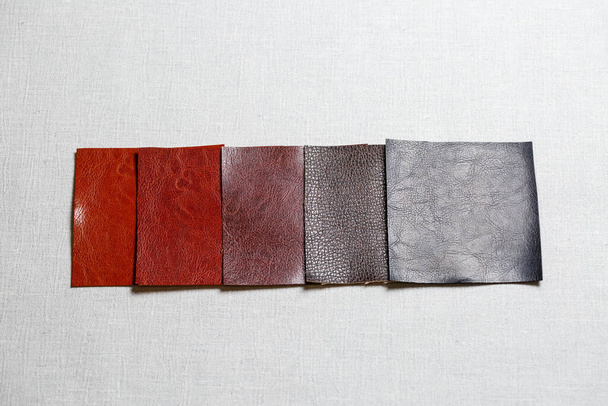 квадратні шматочки різнокольорової тканини, викладені на сірому фоні
 - Фото, зображення
