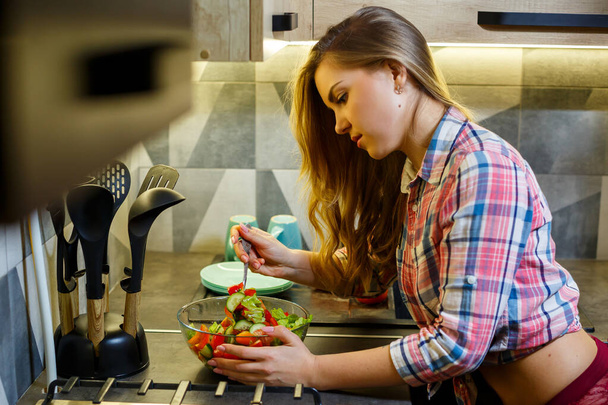 Фітнес дівчина скибочки салат зі свіжими овочами і з'їсти його
 - Фото, зображення