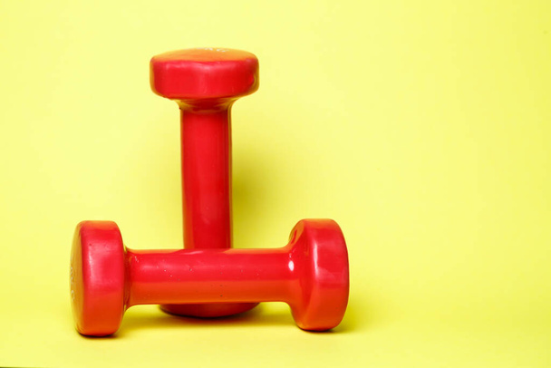 red sports dumbbells on a yellow background - Photo, Image