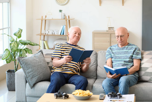 Elderly men reading books at home - Photo, Image