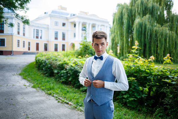 young guy businessman groom on their wedding day, stylish clothing, a walk in the park - Foto, imagen