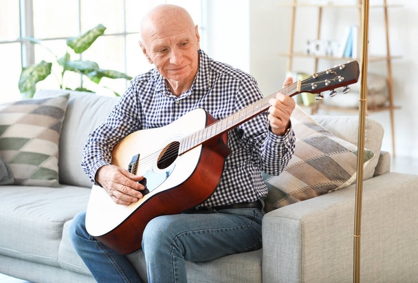 Elderly man playing guitar at home - Φωτογραφία, εικόνα
