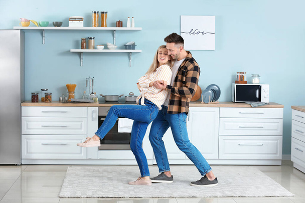 Feliz pareja joven bailando en la cocina
 - Foto, imagen