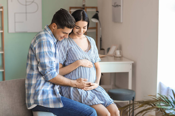Portrait of happy pregnant couple at home - Photo, Image