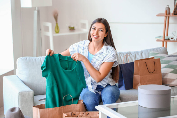 Young woman with new clothes at home. Online shopping concept - Photo, Image