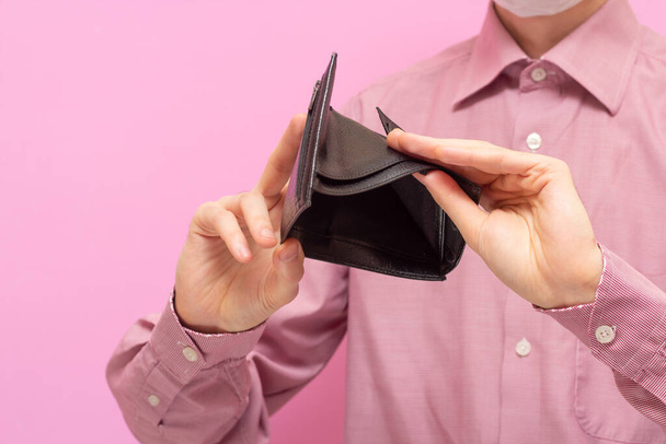The guy shows an empty wallet. On a pink background. No money. A crisis. Financial content - Valokuva, kuva
