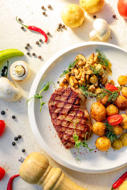 delicious steak with mushrooms and baked potatoes with jalapeno, healthy food - Photo, Image
