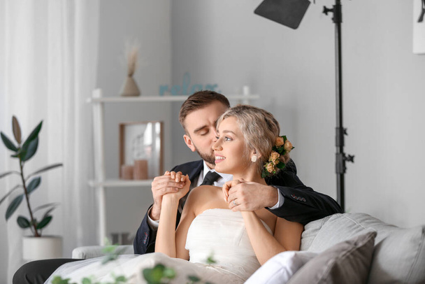 Young wedding couple posing for photographer in studio - Фото, изображение