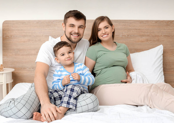 Портрет счастливой семьи в спальне
 - Фото, изображение