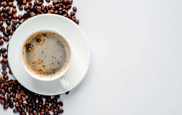 Kopje koffie en koffiebonen op een witte achtergrond met kopieerruimte voor uw tekst. - Foto, afbeelding