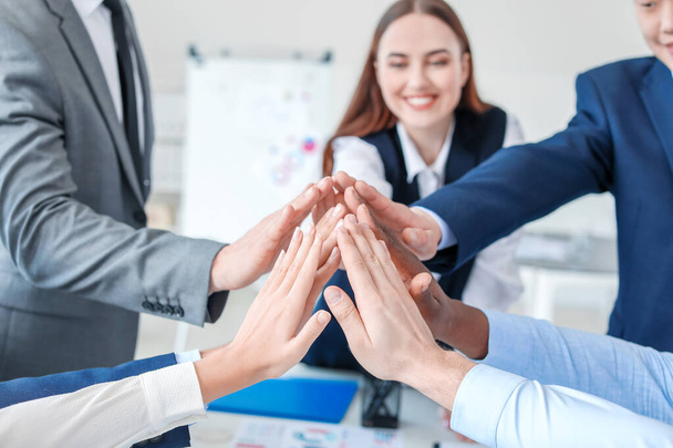 Group of business people putting hands together in office. Unity concept - Photo, image