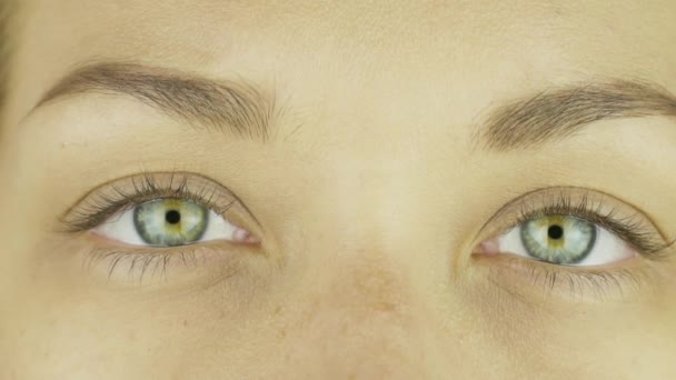 Schöne grüne Augen eines jungen kaukasischen Mädchens ohne Make-up lächelnd. Nahaufnahme - Filmmaterial, Video