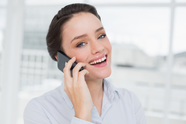 Cheerful elegant young businesswoman using cellphone - Photo, Image